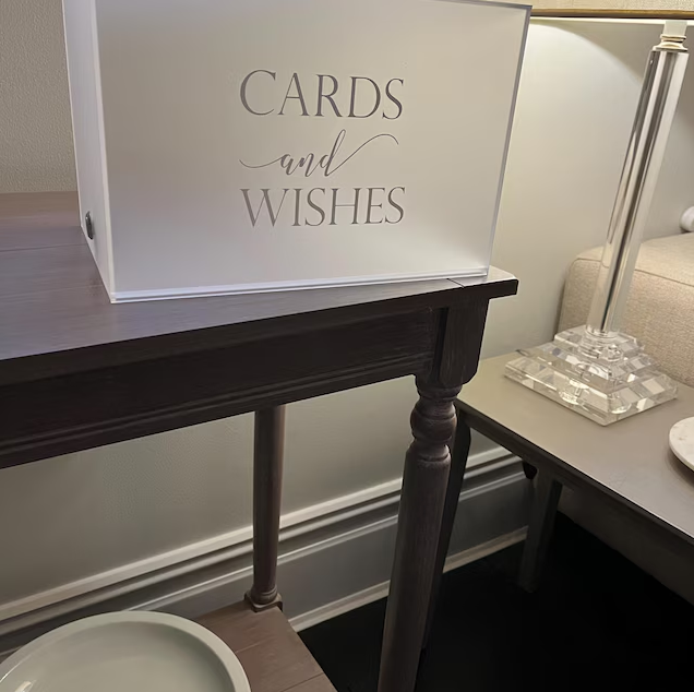 Card holder with 'Cards and Wishes' sign on a wooden table in a room setting.