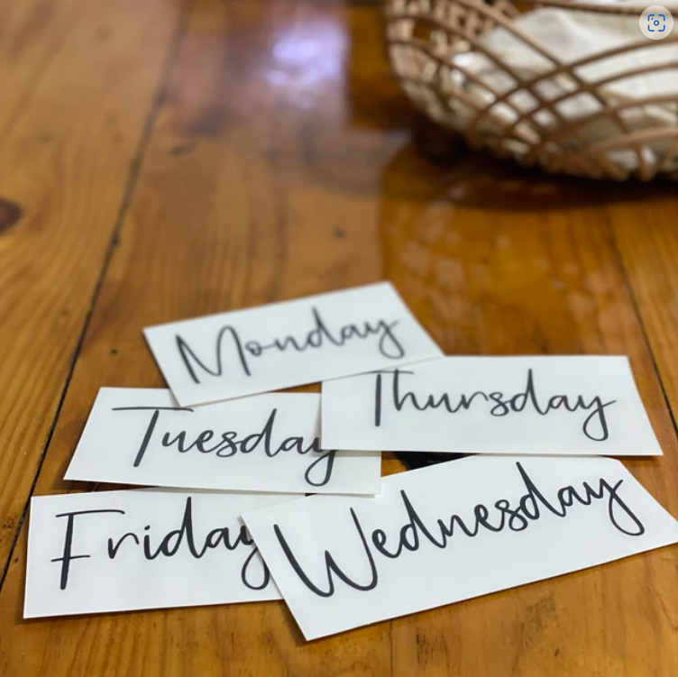 Weekly day labels on a wooden surface